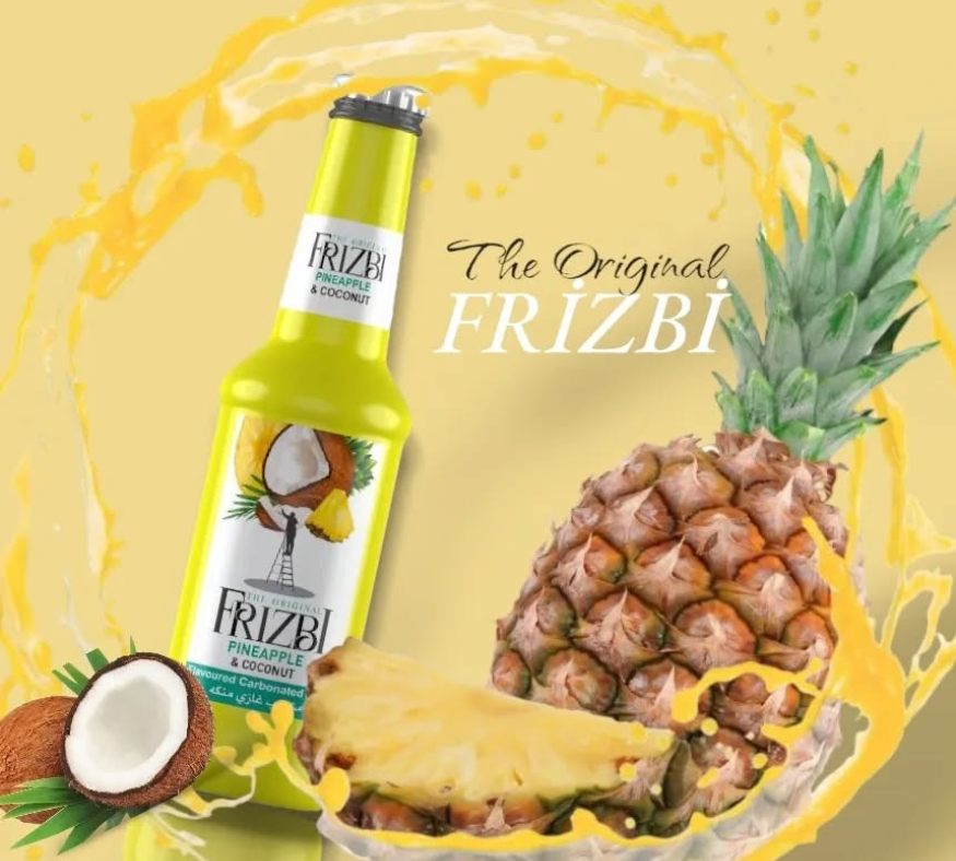 Frizbi pineapple and coconut flavored soft drink bottle with sliced pineapple and coconut on a yellow background.